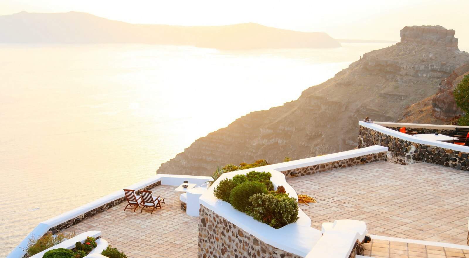 Terrace on mountain overlooking large body of water.