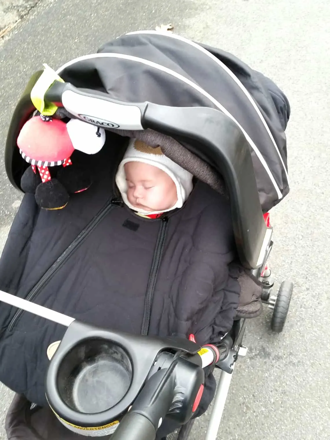 Baby girl sleeps in car seat attached to universal stroller frame.