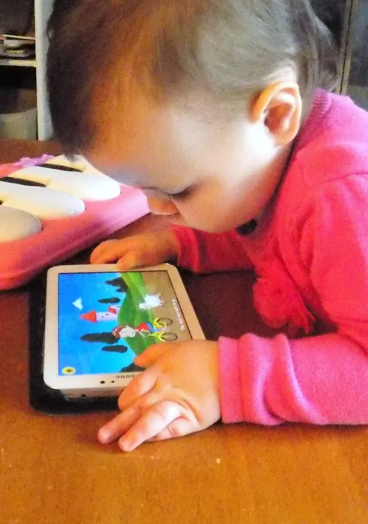 Little girl watches show on tablet.