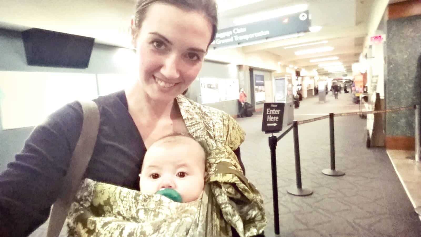 Mom wears baby using baby sling.