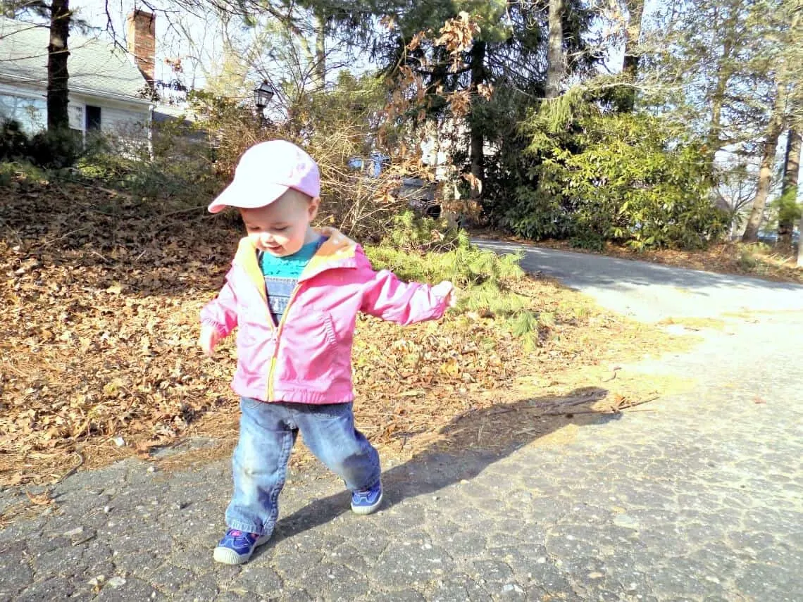 Toddler girl plays outside for spring.