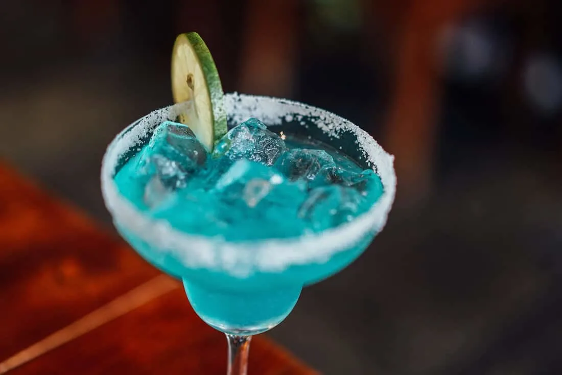 Blue margarita with slice of lime.