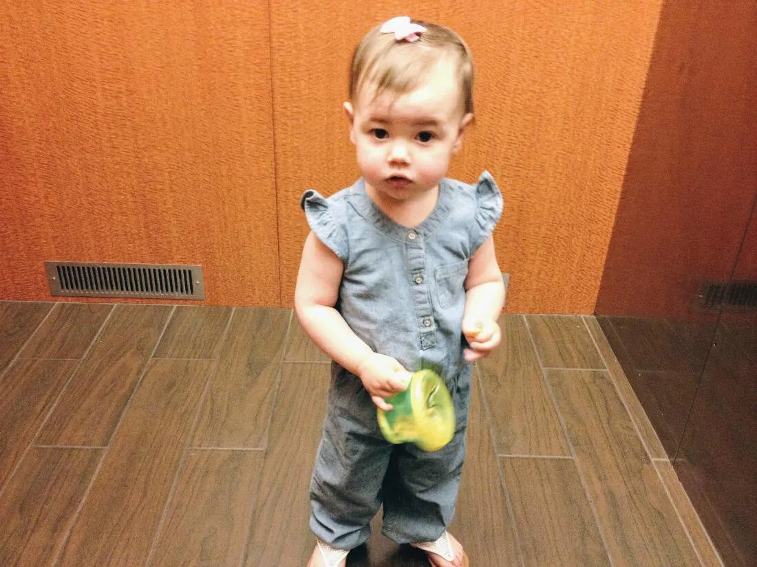 Little girl with green snack cup.