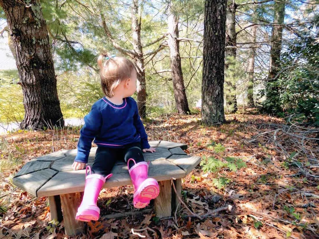Toddler girl plays in wooden area.