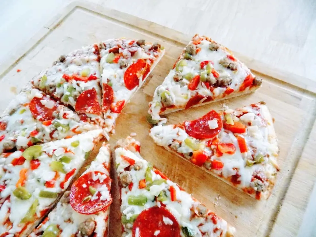 Slices of Red Baron pizza on wooden cutting board.