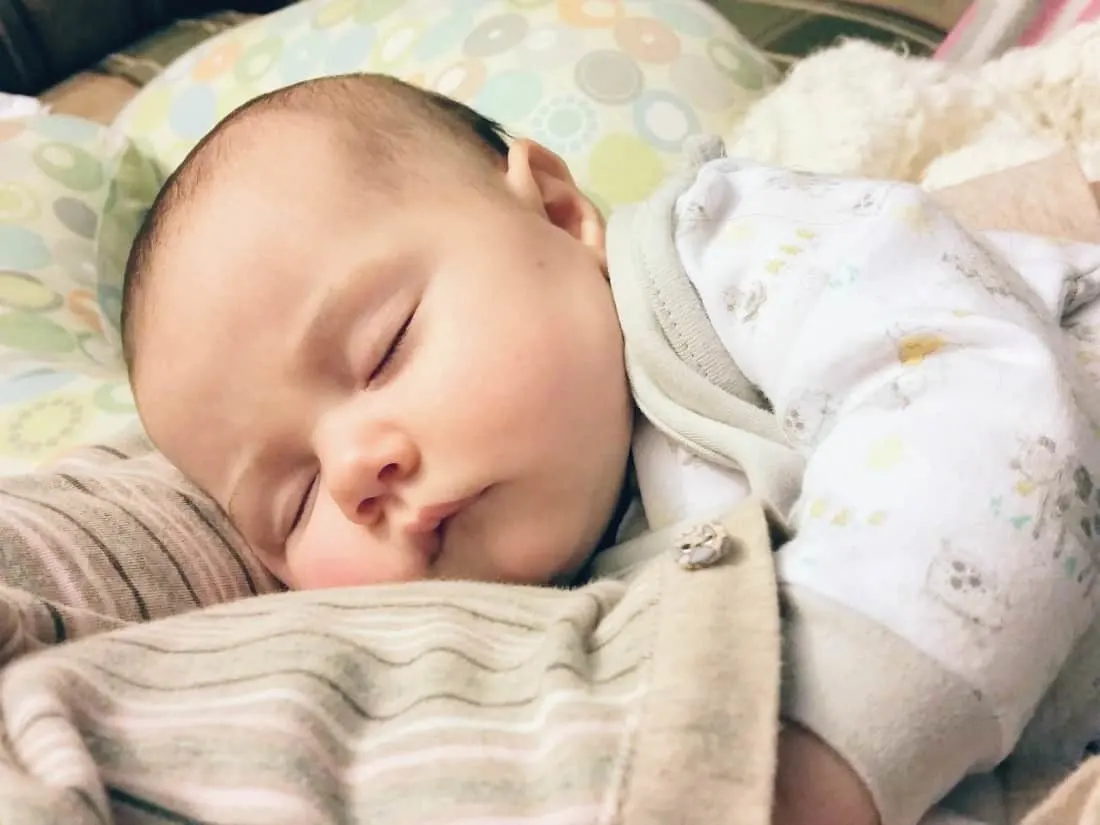 Mother holds baby after feeding infant.