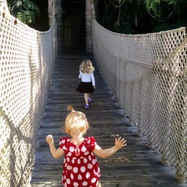 Children walk across bridge at Disneyland.