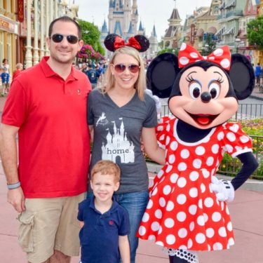 Family poses with Mini Mouse at Disneyland.