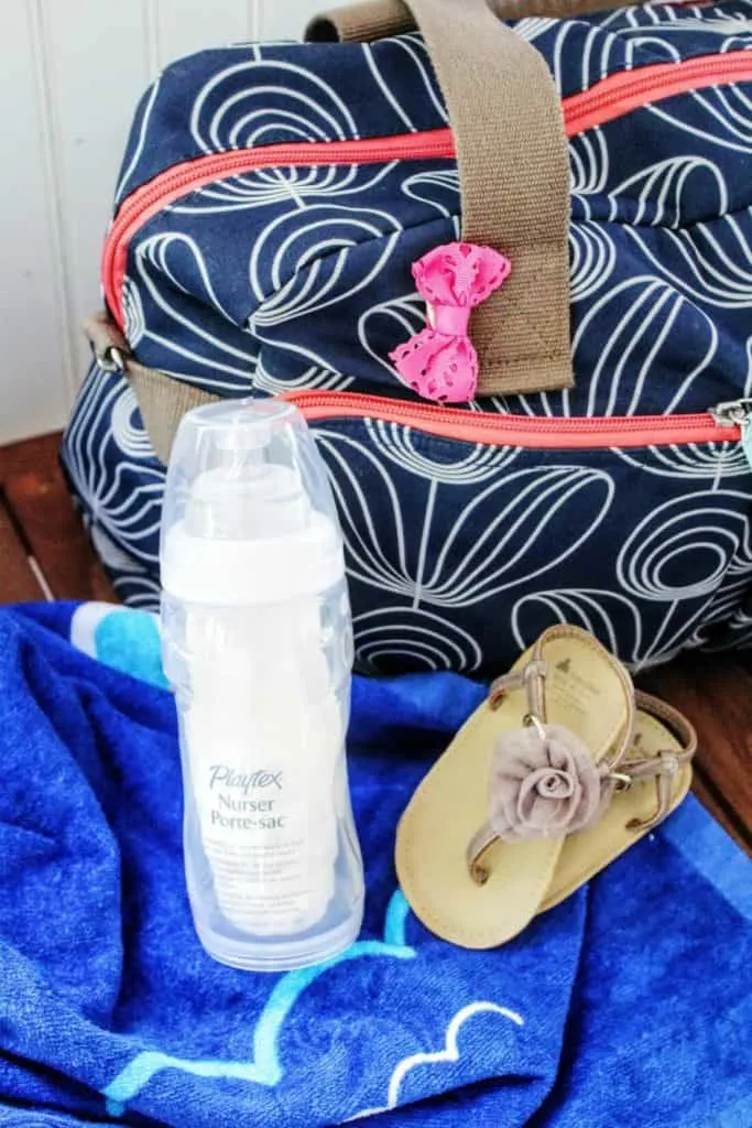 Beach bag and baby bottle next to flip flops.