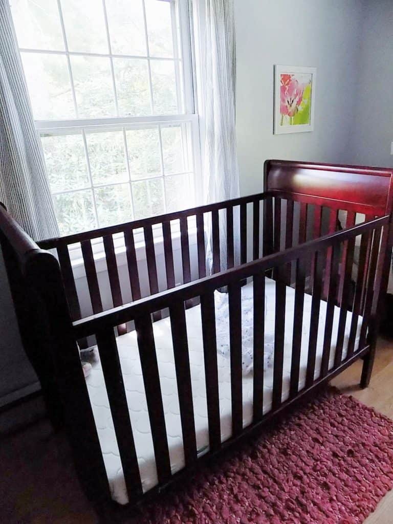 Crib in baby girl nursery.