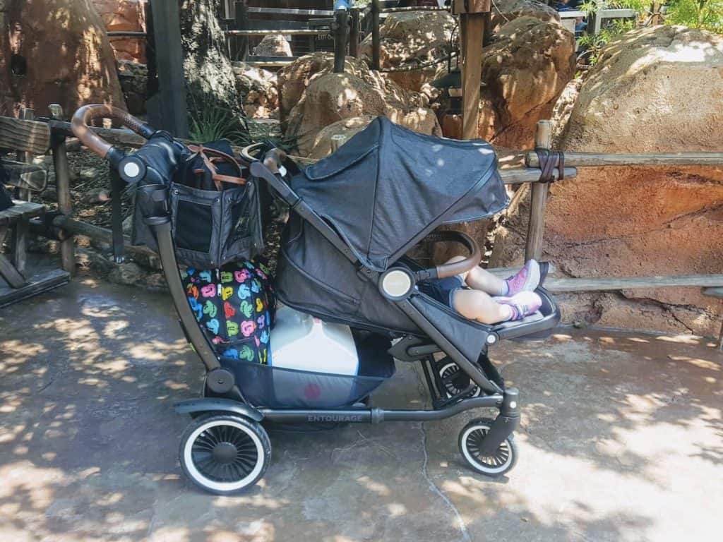 Girl sits in Austlen Entourage stroller at Disney park.