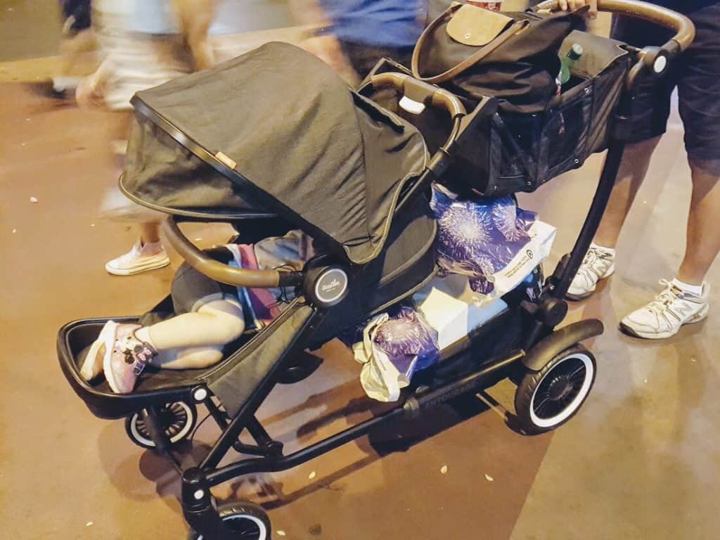 Stroller full of toddler supplies and sleeping toddler.