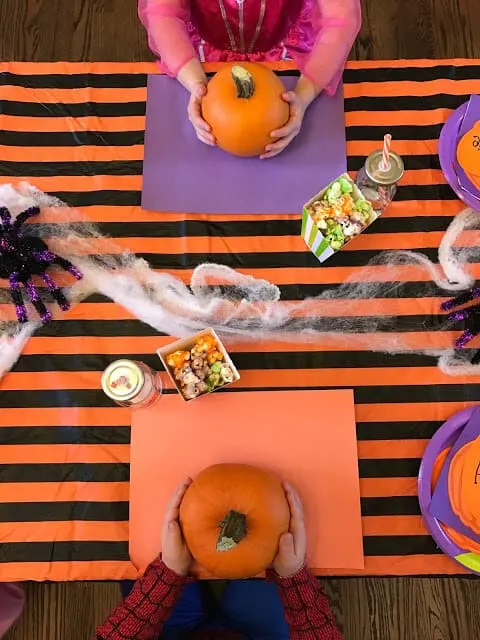 Children participate in fun Halloween ideas at table.