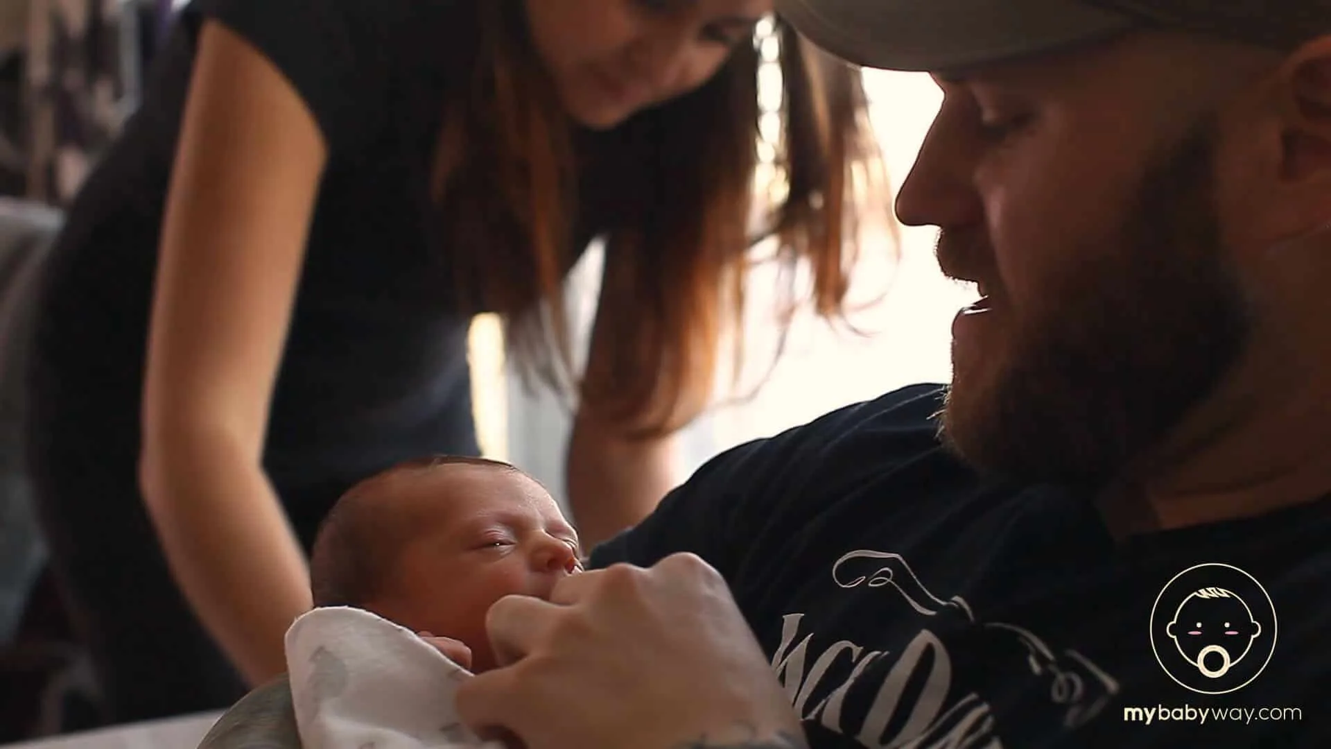 Parents hold newborn baby.