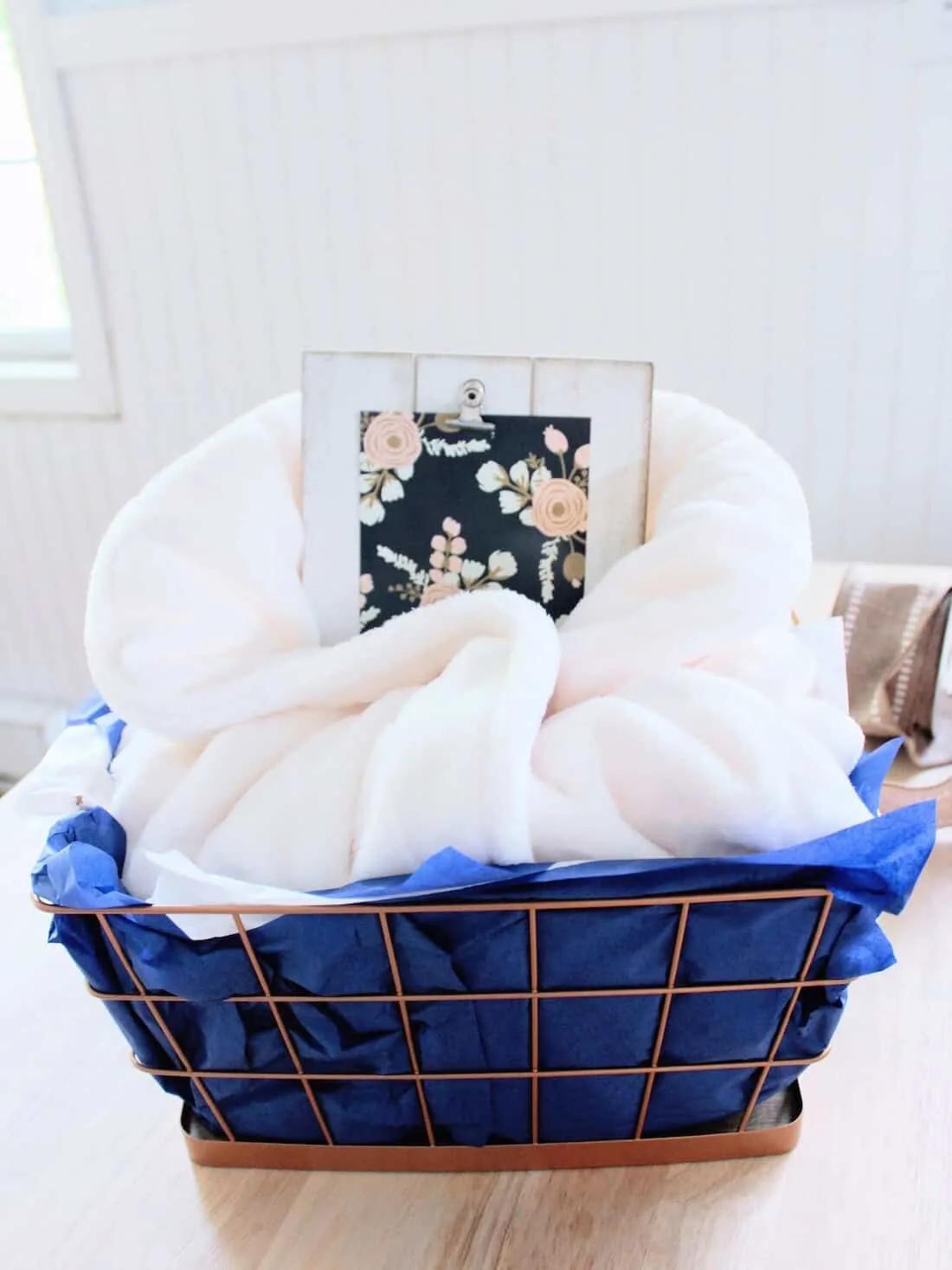 New mom gift basket with blue tissue paper.