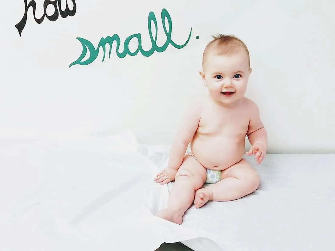 Baby girl sits in medical room for examination.