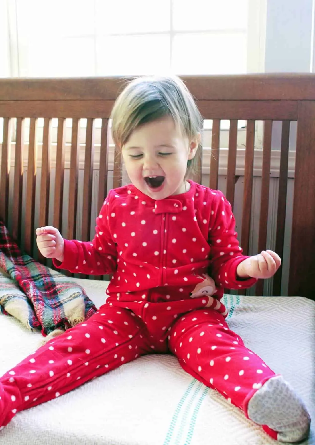 Girl lifts hands in excitement for Christmas.
