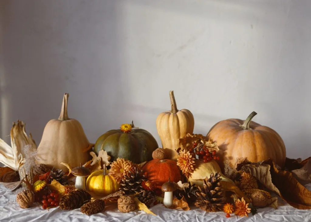 Pumpkins and fall foliage on a table centerpiece.