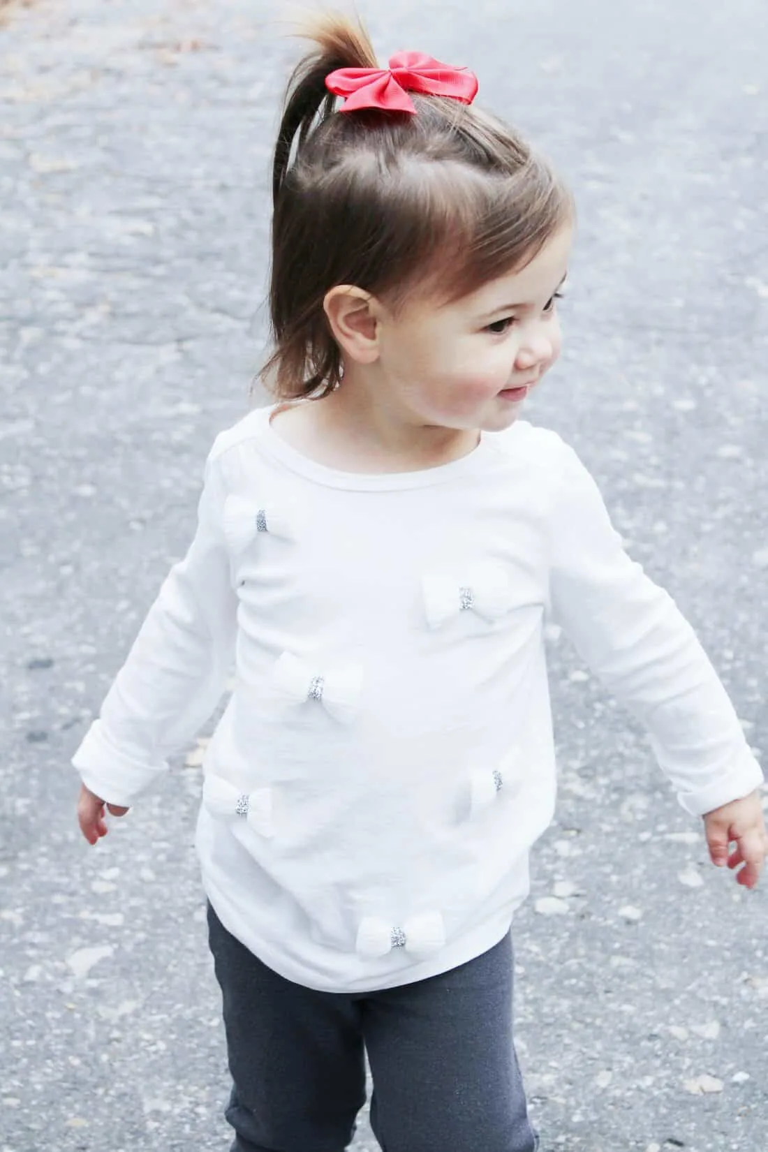 Toddler girl walks down road.