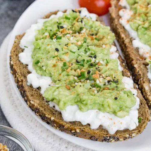 Toast with cottage cheese, avocado, and seasonings on top.