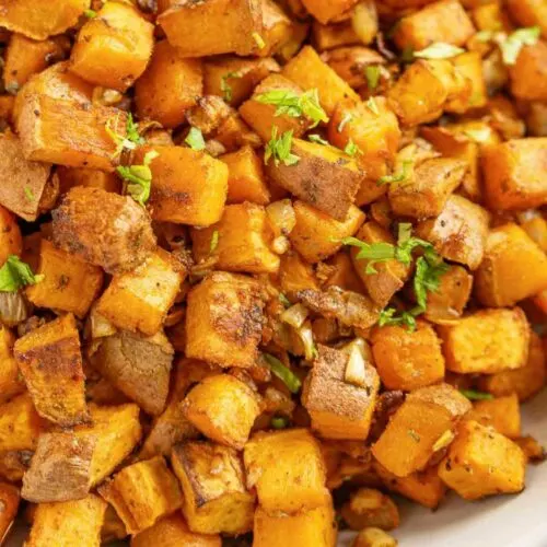 Sweet potato home fries with green garnish.