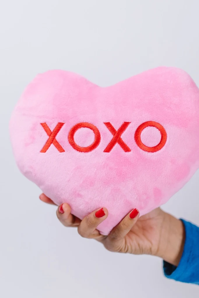 A pin confection hearts pillow with "xoxo" in red.