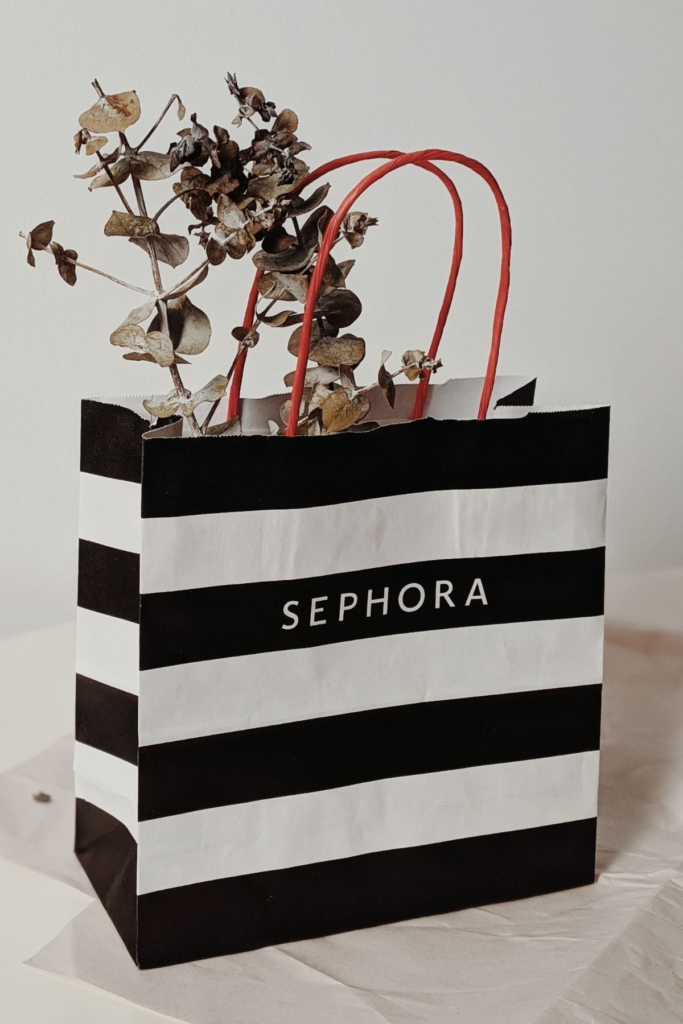 A black and white striped Sephora bag with flowers in it.