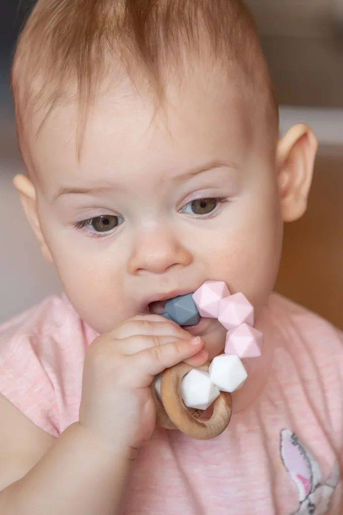 A baby chews on a teething bracelet.