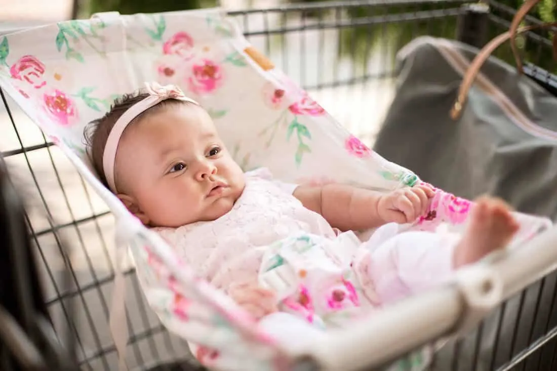 Baby in shopping cart sling.