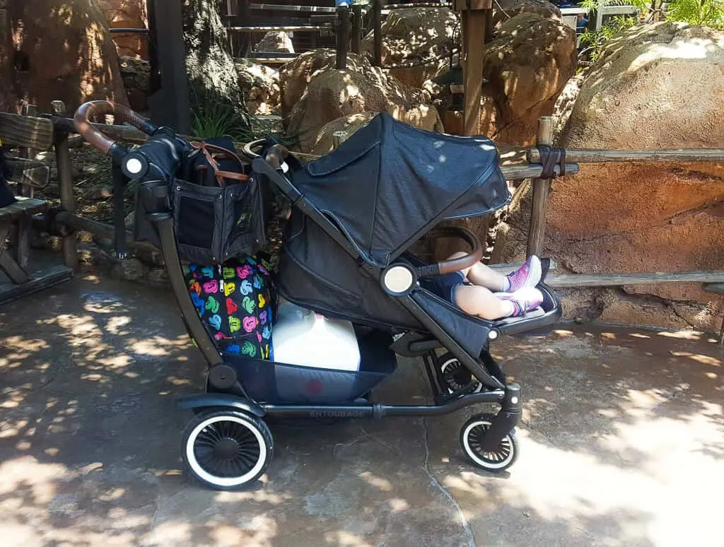 Toddler girl sits in stroller at Disney.