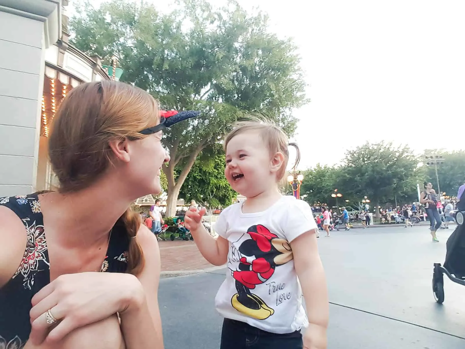 Mother kneels down to interact with her daughter at Disney.