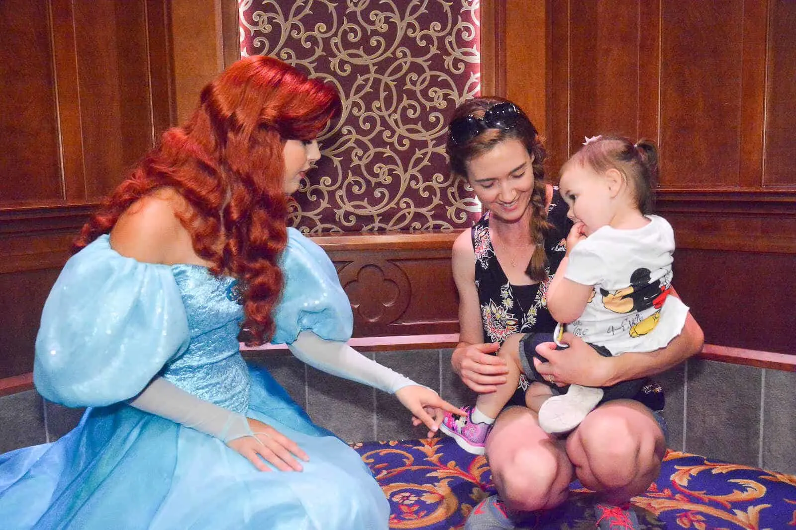 Mother introduces toddler girl to princess at Disney.