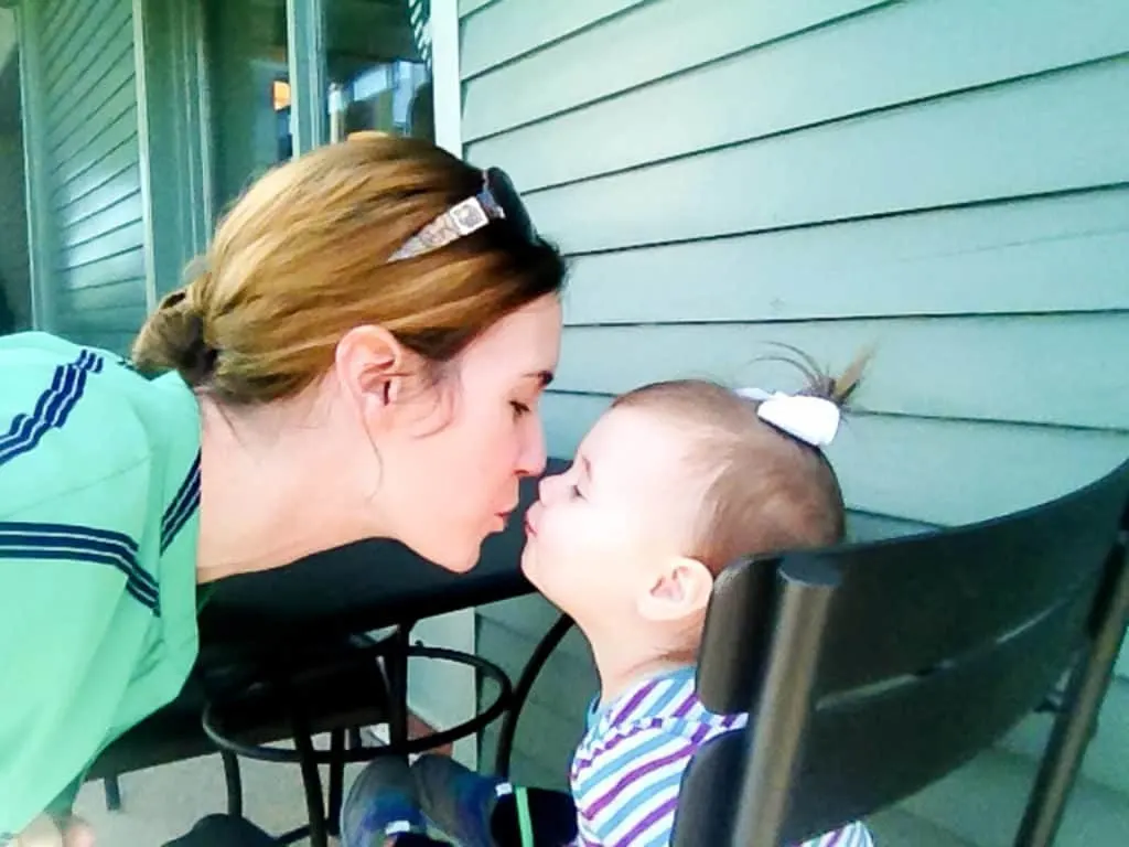 Woman kisses baby girl.