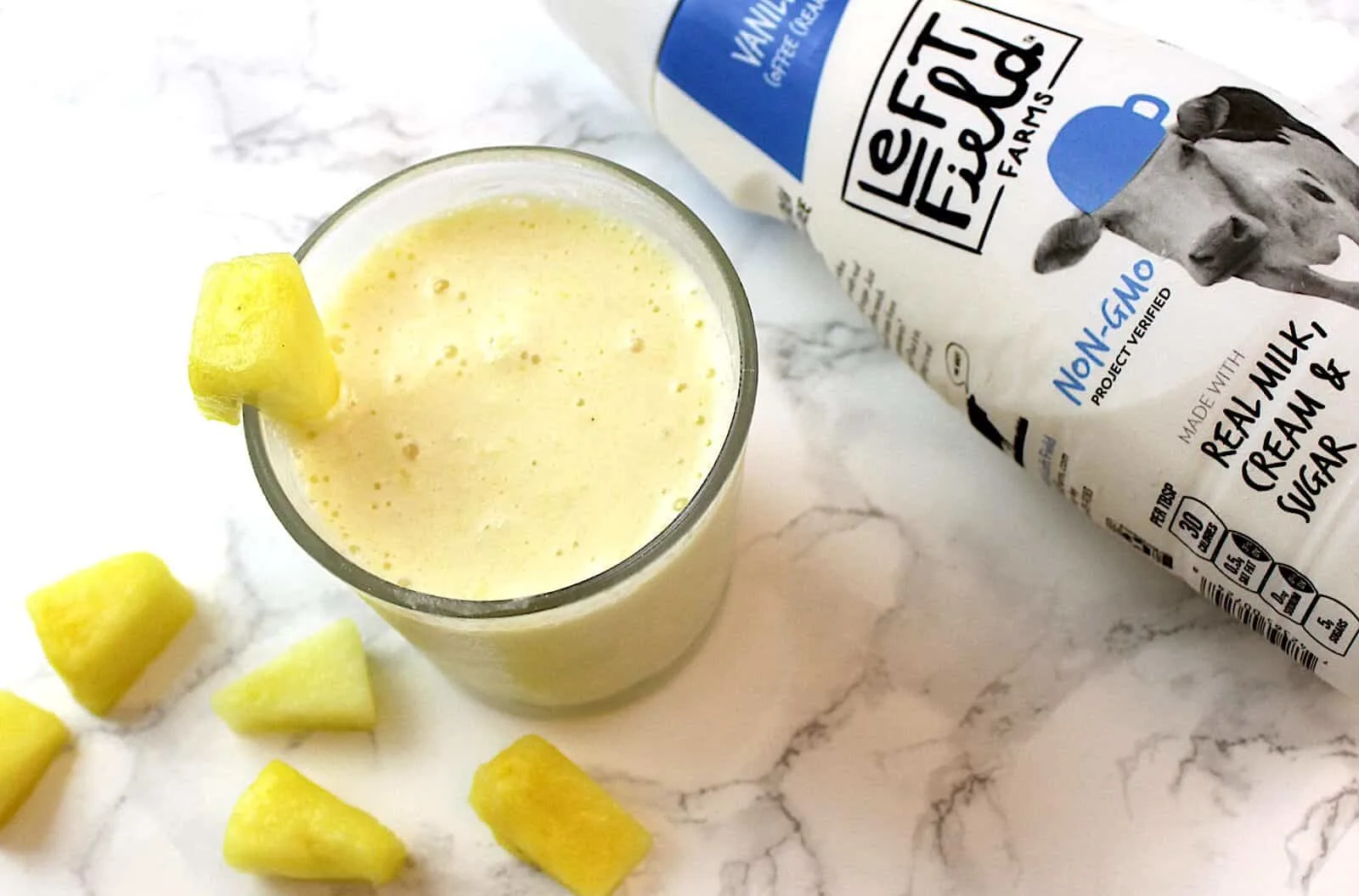 Dole whip smoothie with pineapple garnish next to bottle of left field milk.