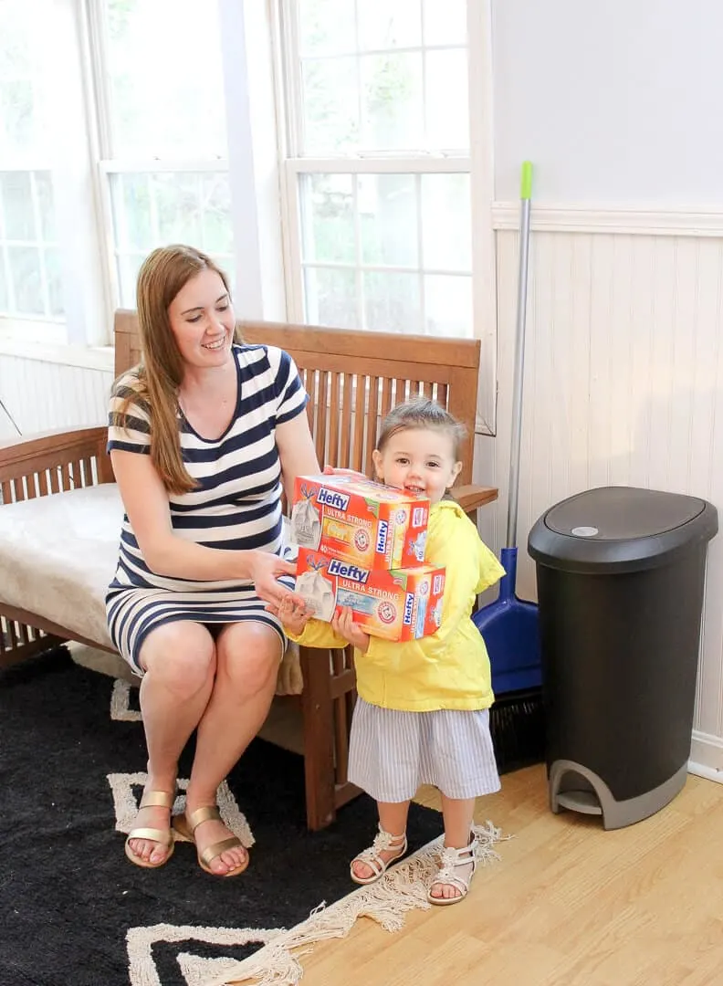 Mother and daughter hold boxes of trash bags from hefty.