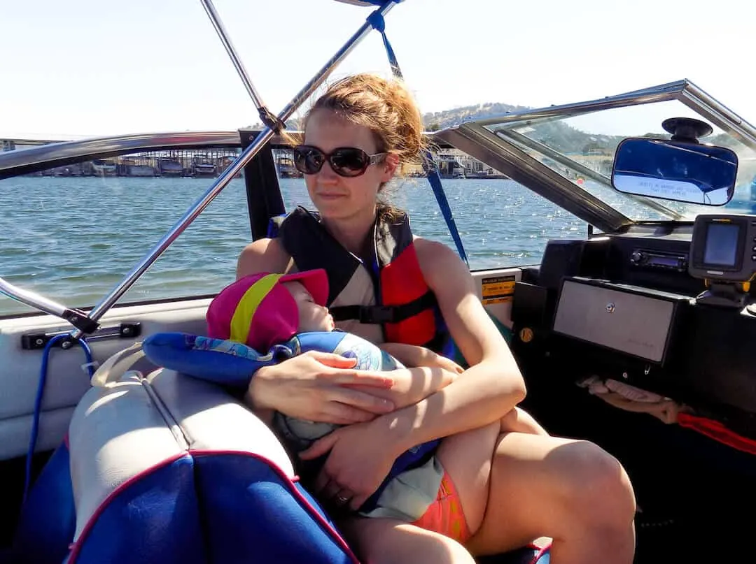 Mother holds baby girl while boating.