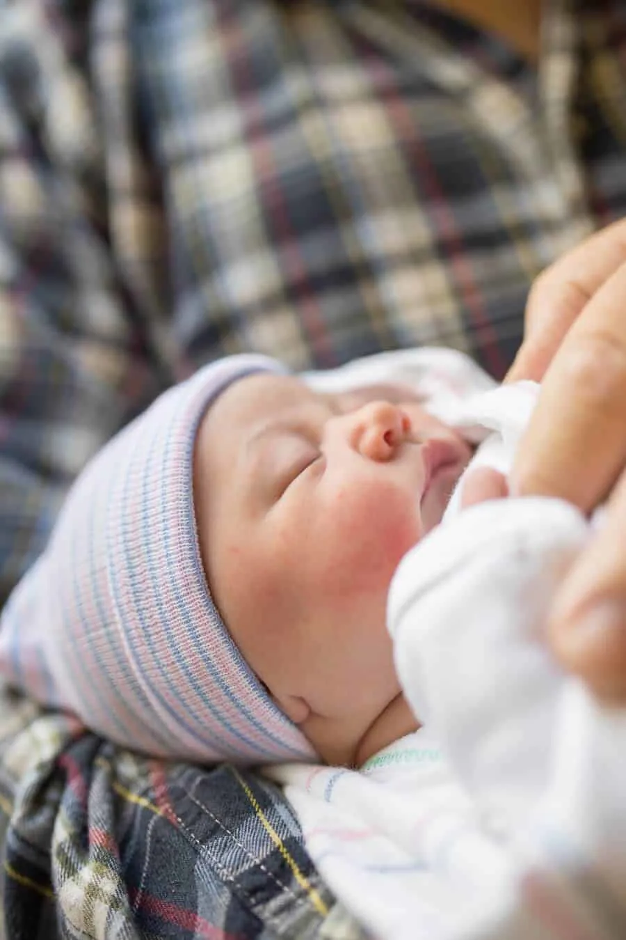 Grandfather holds newborn in hospital.