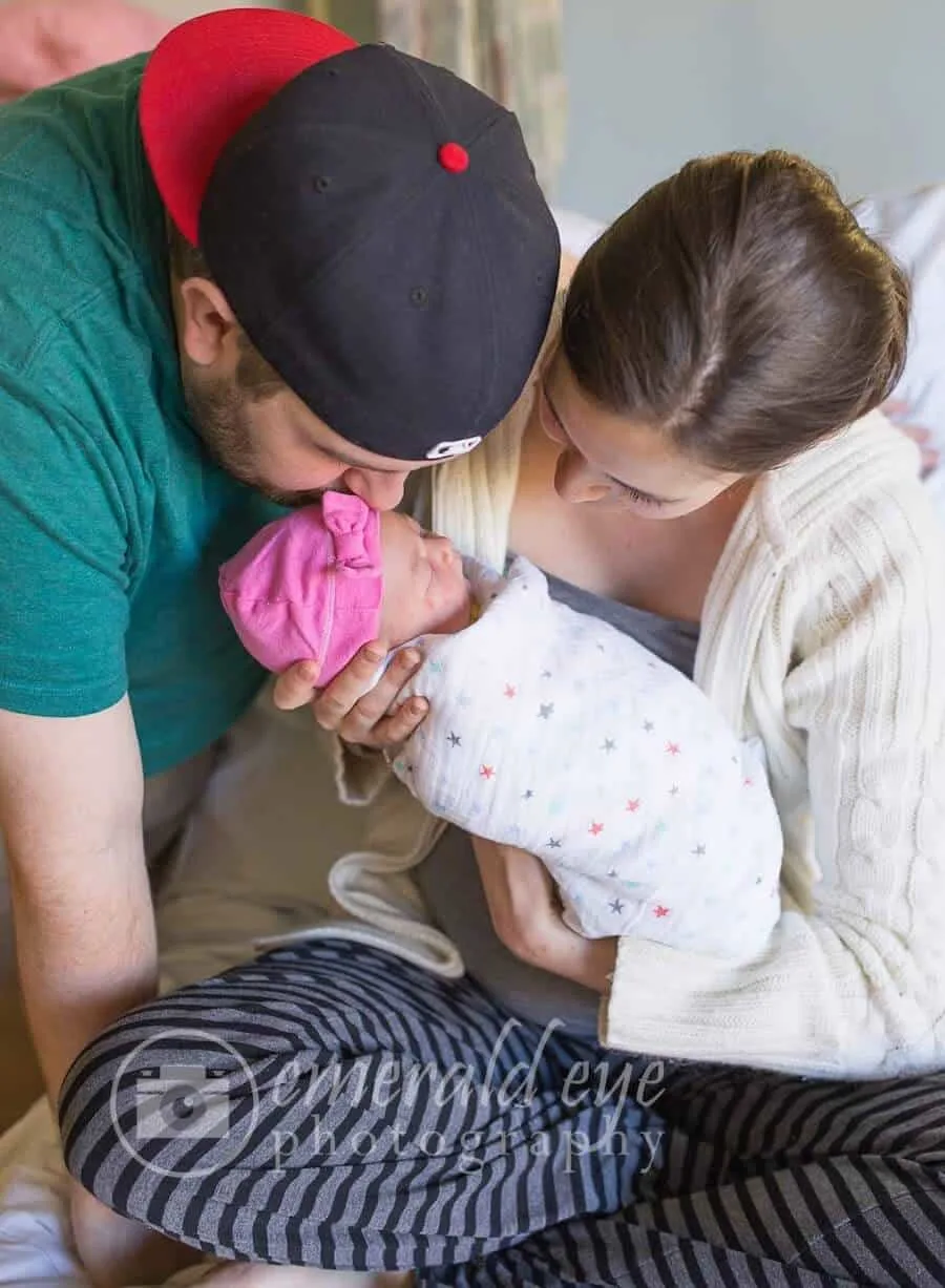 Couple holds newborn baby girl.