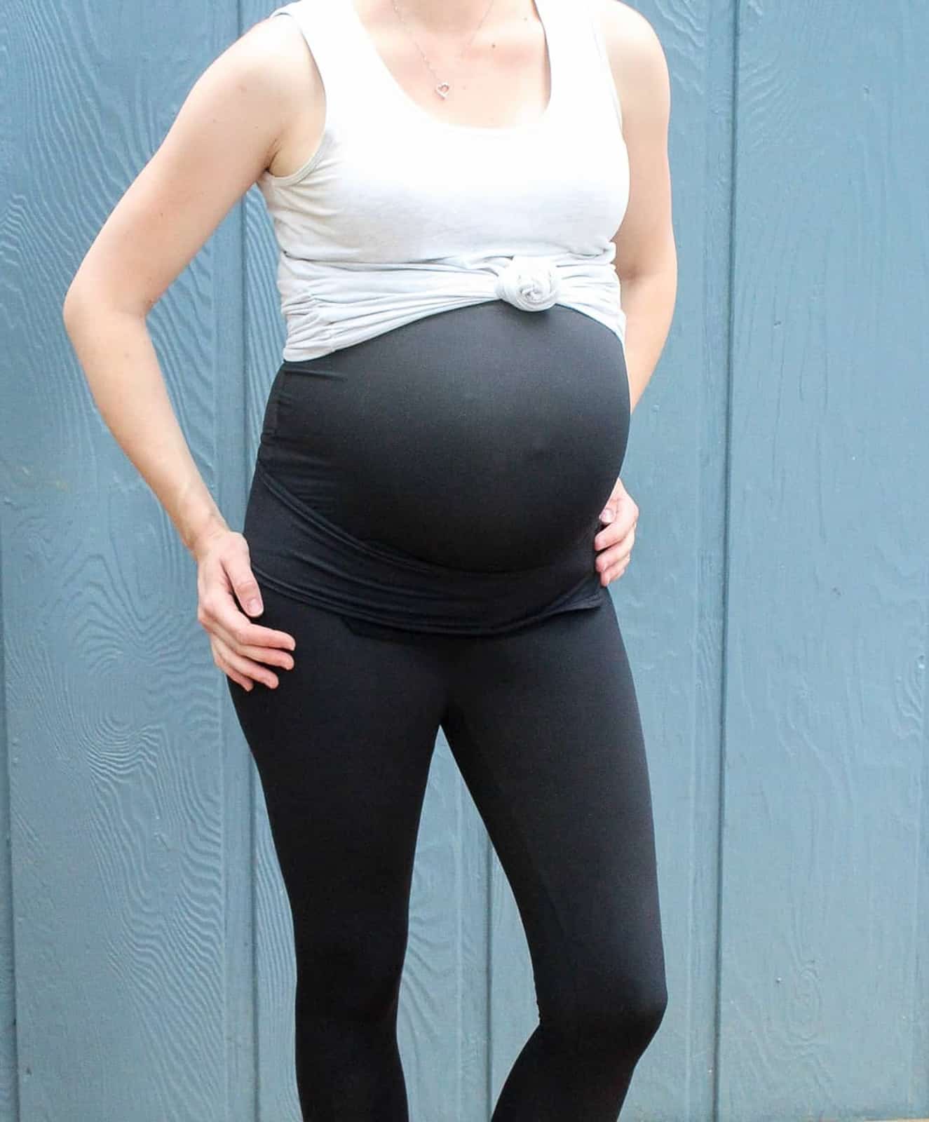 Pregnant woman wears maternity leggings during final trimester.