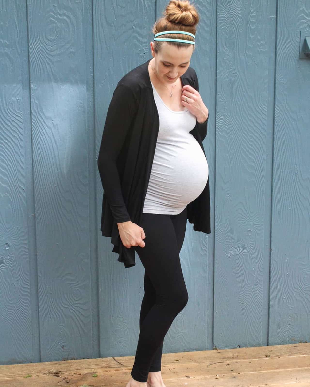 Pregnant woman models maternity leggings for 3rd trimester.