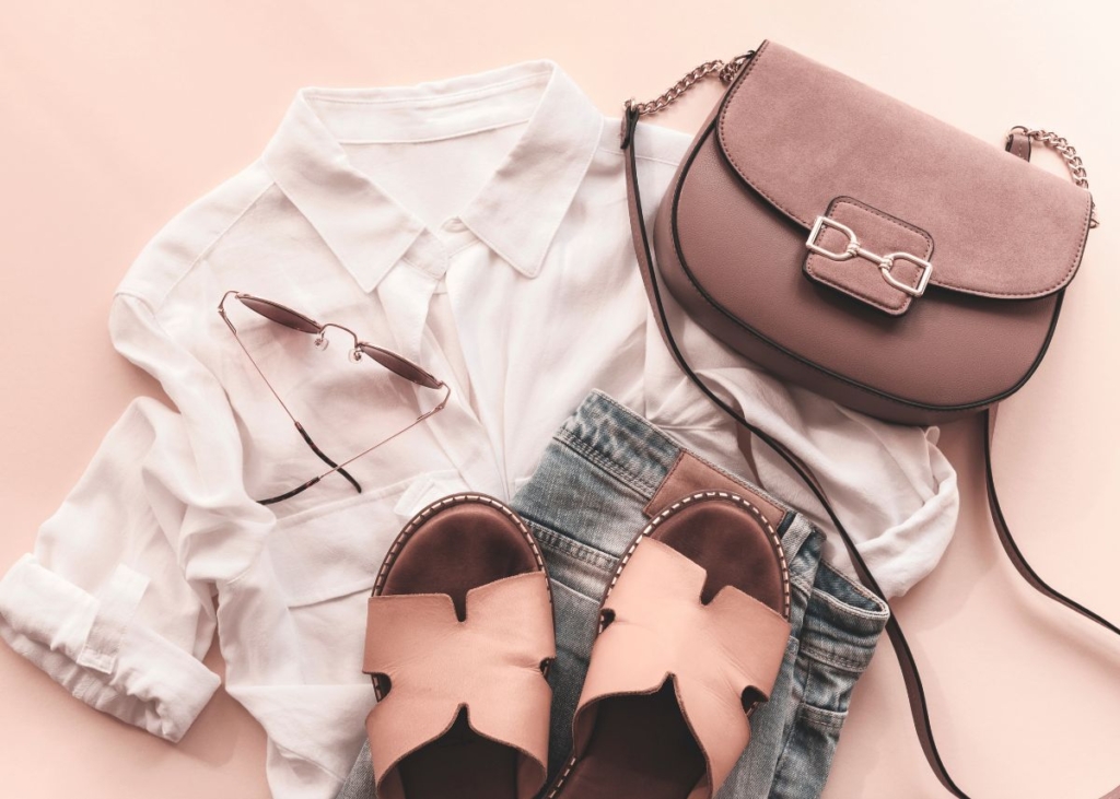 Cream blouse, jeans, sandals, and a brown bag flat lay outfit.