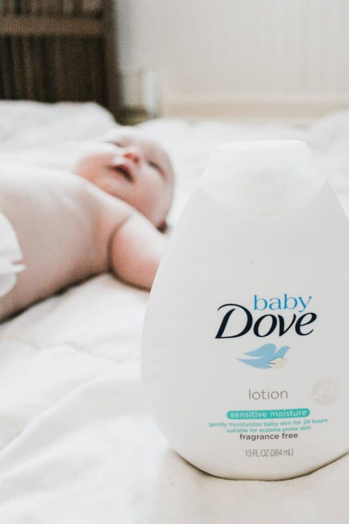 Baby Dove lotion with baby laying in background.