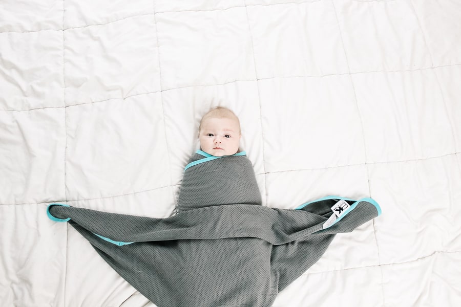 final step of the boat swaddle for a baby: tuck in the extra fabric