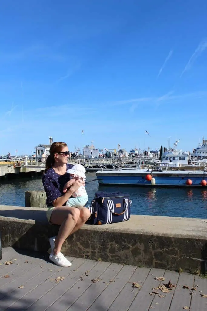 Mom sits with baby on dock in Provincetown.