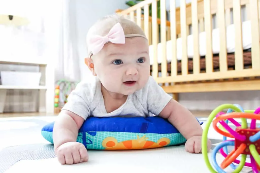 Baby does tummy time with play toys.