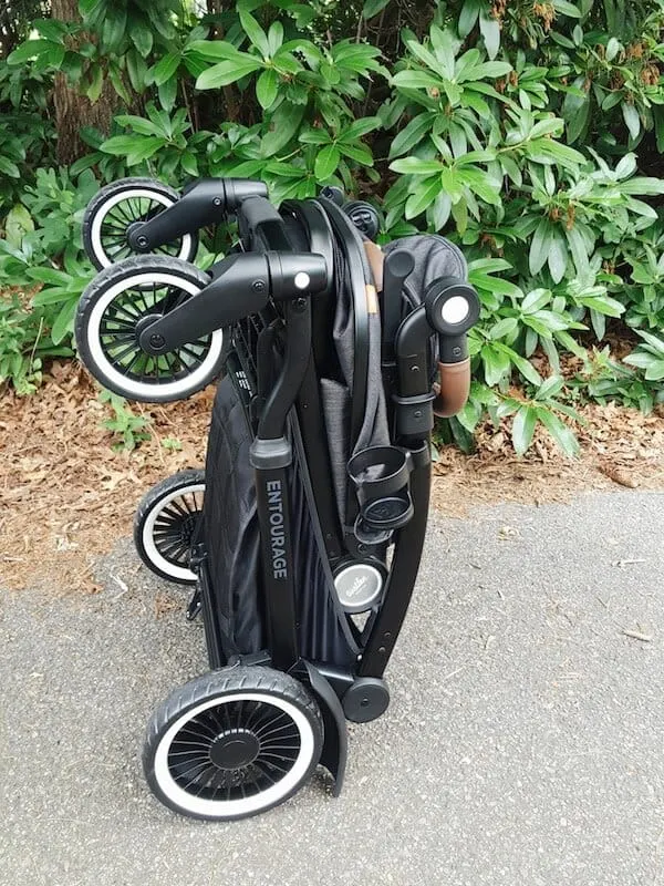 Stroller is folded together on walking path.