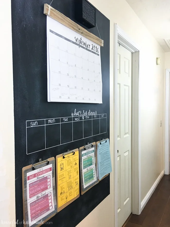 Chalkboard paint hallway command center with calendar and clipboards.