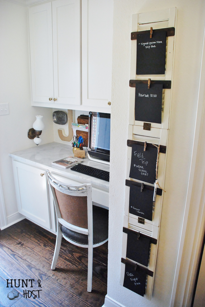 A to-do-list chalkboard organizer on upcycled shutters next to a built-in desk with cabinets above it.