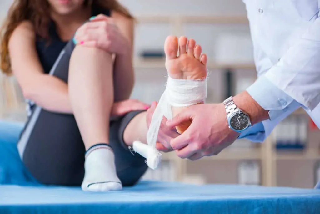 Doctor taking care of a bandaged foot.