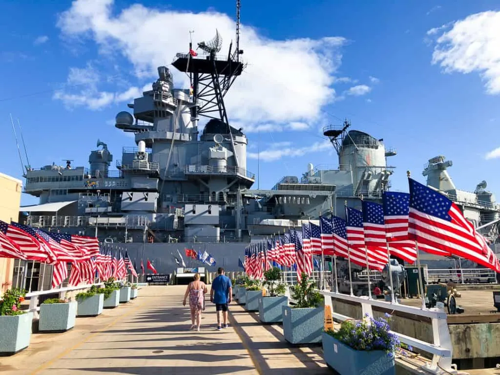 Ship in front of American flag lined dock.